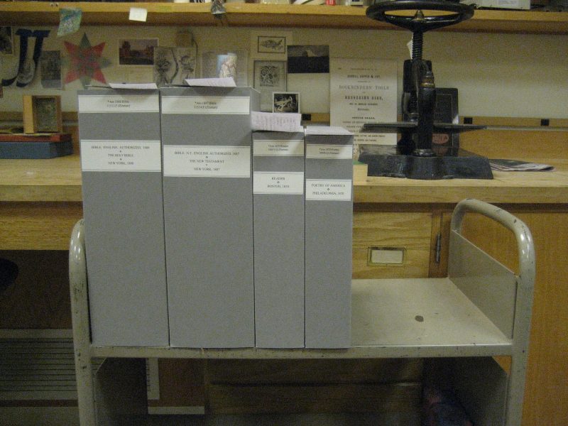 Four clamshell boxes sitting on a library cart.