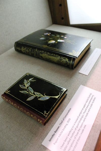 Two examples of papier-mâché bindings laid out in an exhibition case, 2010. Jennifer Rosner, Chief of Conservation.