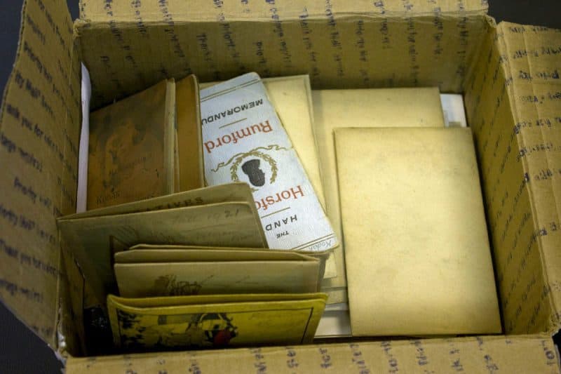 View inside a box of new acquisitions. Folders and leaflets are scattered throughout the box.