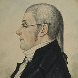 Waist-length oval profile portrait of man with long gray hair wearing dark suit and spectacles