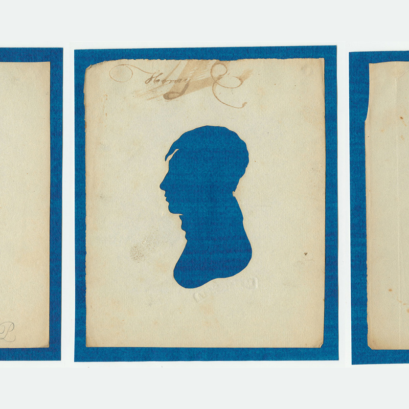 Three early 19th-century cut-out profile silhouettes of two men and one women on blue paper.