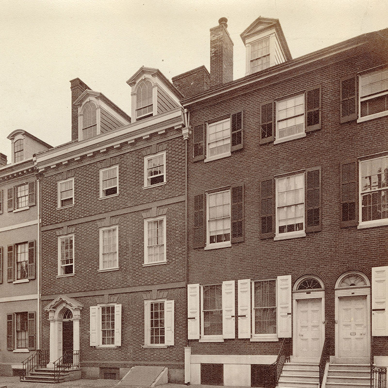 Exterior view showing four 18th-century city row homes.