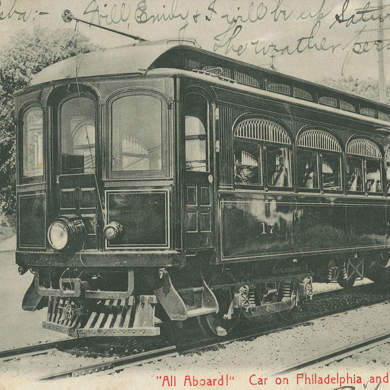 View showing a trolley on street tracks. Handwritten note is written along upper edge and in corner of image.