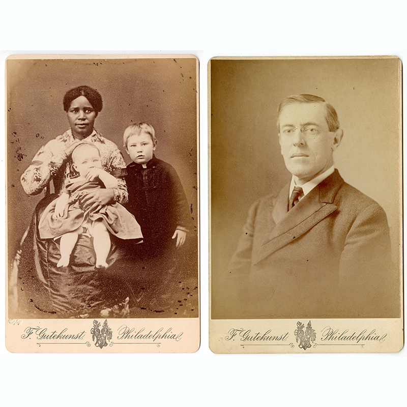 Nineteenth-century three-quarter length portrait photograph of Black woman holding a white baby in her lap while a white boy stands by her side.
