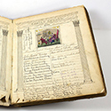 An open book showing colorful drawings and a handwritten record of dates
