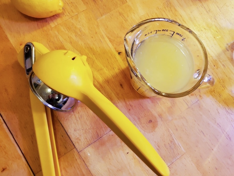 Adding strained lemon to the sugar water mixture