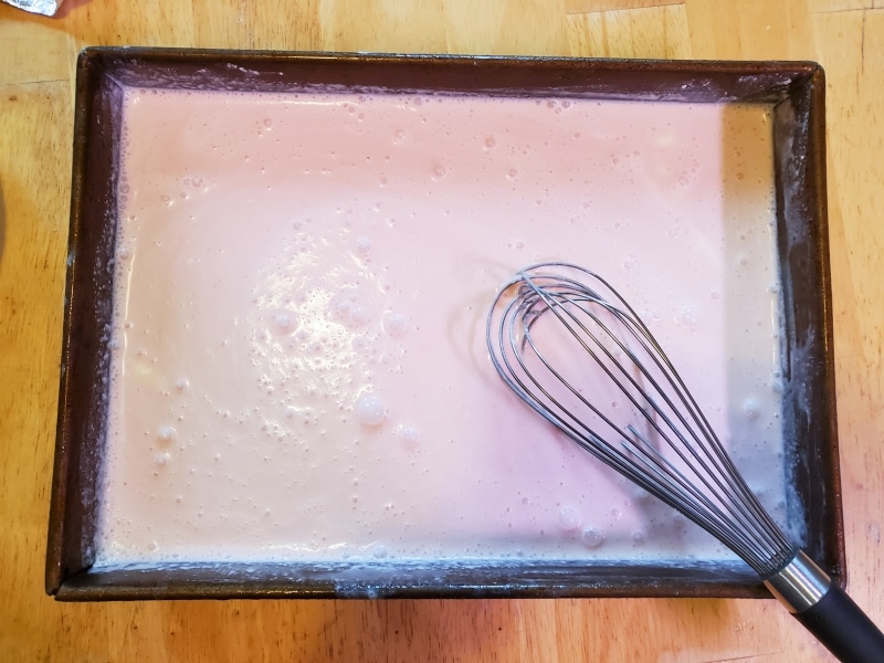Metal pan filled with evenly mixed juice and cream.