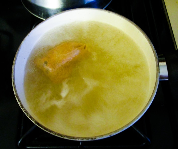 Boiling spices in a cloth bag with vinegar and water to make a brine