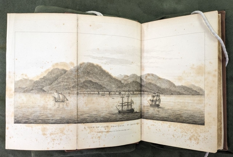 Print showing harbor with several ships at sail, and buildings and mountains in the background
