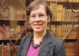 Photograph of Dana Dorman in front of bookcase