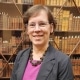 Photograph of Dana Dorman in front of bookcase