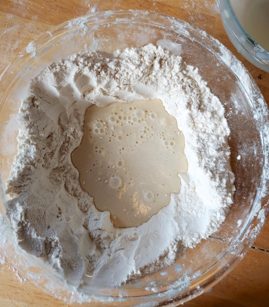 Image of the dry ingredients with the wet ingredients in a well.