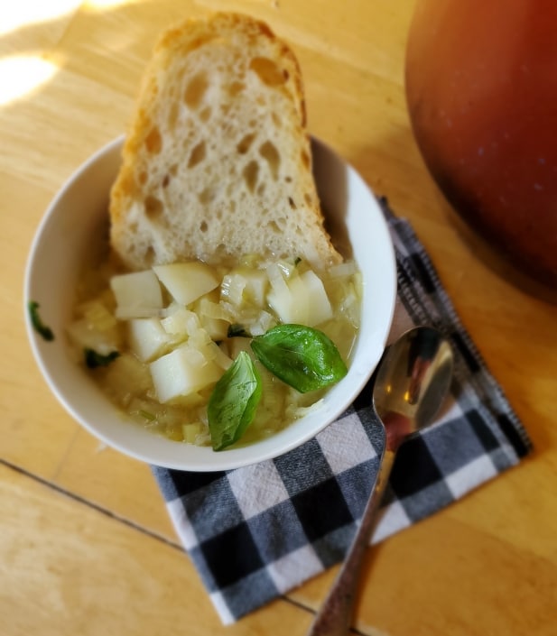 bowl Leek Soup served with fresh crusty bread and basil.