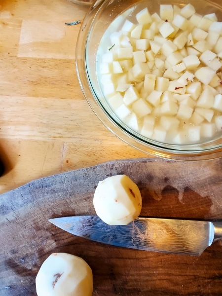 Diced potatoes in a bowl of water to keep them from discoloring.